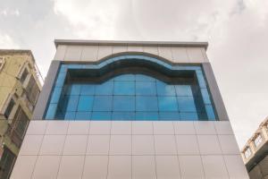 班加罗尔Octave Plaza Hotel的一座高大的玻璃建筑,拥有蓝色的窗户