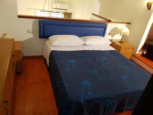 圣欧费米亚拉默齐亚Modern Apt REVENTINO - Le Lincelle, Lamezia的一间卧室配有一张带蓝色棉被的床