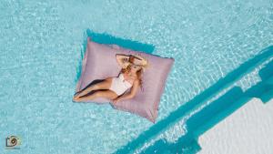 甘地达萨莲花简易别墅酒店的躺在游泳池枕头上的女人