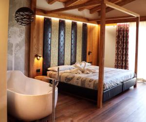 马洛斯科帕诺拉马疗养度假酒店的一间卧室配有一张床和一个浴缸。