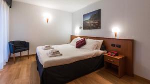 奇萨瓦玛兰科Residence Pizzo Scalino的酒店客房设有一张带床头柜和椅子的床。