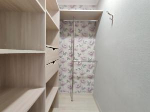 博布鲁伊斯克Apartament on Oktyabrskaya 132的步入式衣柜,配有带花卉淋浴帘的淋浴