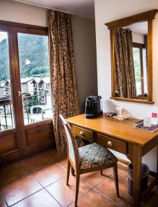 阿林萨尔维尔杜小屋酒店的一张木桌,靠窗边摆放着椅子