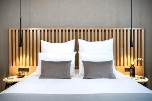 塞萨洛尼基Porto Palace Hotel Thessaloniki的卧室配有带枕头的大型白色床