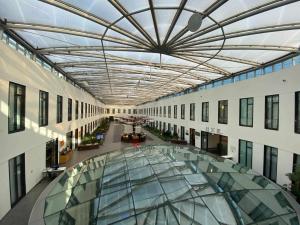 柏林柏林美居农业酒店的一座建筑的空走廊,有玻璃天花板