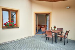 多尼杜纳约维采沃拉里克旅馆的一个带桌椅的庭院和一个窗户。