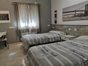 莱加内斯Villa "Luna de Segovia"的酒店客房配有两张床和一张书桌