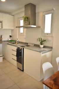 罗萨里奥Luminosos y modernos departamentos en Rosario的厨房配有白色橱柜和台面