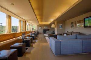 吉马良斯帆迪朵酒店的带沙发、桌子和窗户的等候室