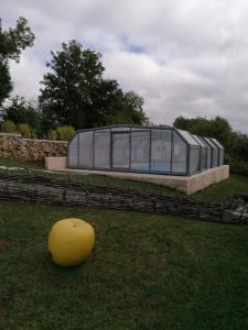 BucillyGîte La feuille d'Acanthe的草上一个黄色球的大型玻璃屋