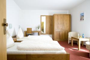 多尔马根弗洛拉酒店的一间卧室配有两张床和一张桌子及椅子