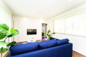今津Shiga Lakeside Villa的客厅配有蓝色的沙发和电视