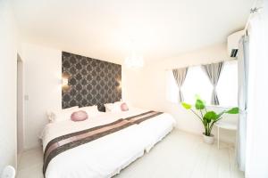 今津Shiga Lakeside Villa的白色卧室配有带粉红色枕头的大床