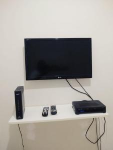 里约热内卢森塔纳坦姆波拉达 - 科帕卡巴纳圣母公寓的白色架子上的电视和遥控器