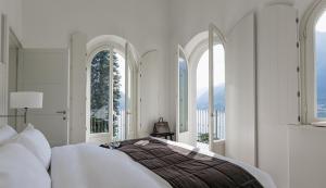 波尼亚纳拉廖科莫湖拉里奥公寓式酒店的一间卧室配有一张带窗户的大床