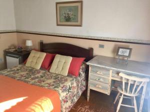库尼亚Fazenda Alvorada的一间卧室配有一张带书桌和一张书桌的床。