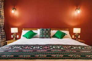 韦科Pivovar Hotel的一间卧室配有一张带绿色枕头的大床
