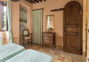 特拉西梅诺湖畔托罗朱利亚别墅农家乐的一间卧室设有两张床、一个梳妆台和一扇门。