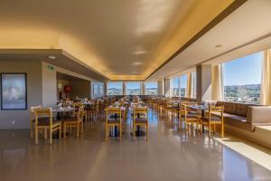 吉马良斯帆迪朵酒店的用餐室设有桌椅和窗户。