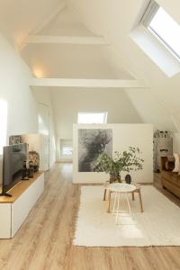 海牙Huize Copes apartment Den Haag, 2 bed, 2 bath的白色的客厅配有桌子和电视。