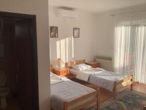 Široki BrijegSobe Pipić的一间卧室设有两张床和窗户。