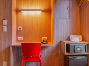 阿雷格里港Hotel Moov Porto Alegre的带微波炉的房间的红色椅子