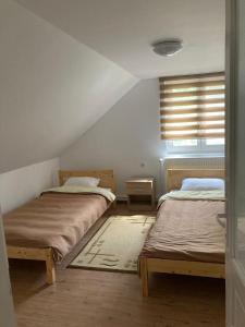 BorzontBükkfői vendégház的一间卧室设有两张床和窗户。