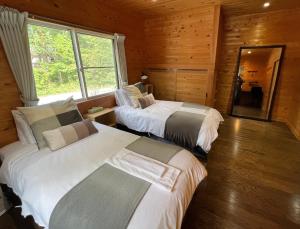 白马村Hinoki Cabin Hakuba 1 - Vacation STAY 76723v的木间设有两张床,设有窗户