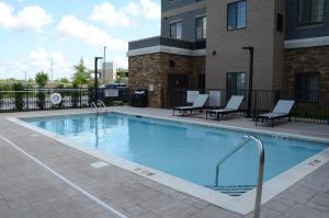 默夫里斯伯勒Staybridge Suites Nashville SE - Murfreesboro, an IHG Hotel的一座带椅子的大型游泳池和一座建筑