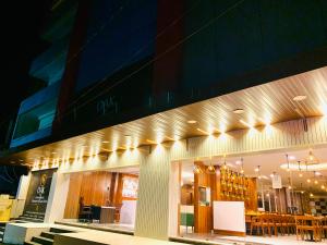 商沙巴Hotel oak by signature airport zone hyderabad的一座配有桌椅的建筑前的商店