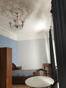 第聂伯罗Ermitage Apt, Апартаменти в Центрі Дніпра的一间卧室配有一张床、一张桌子和一个吊灯。