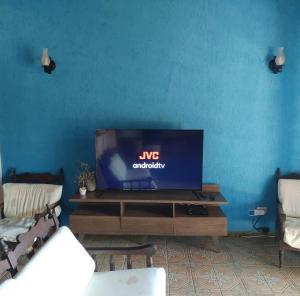 皮尼亚尔齐纽Recanto do Luar的客厅配有一张桌子,电视
