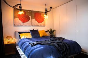 SeafordLuxury Cozy 2Bdr Apt WiFi ☆ Netflix ☆Gas Log Fire的一间卧室配有一张带蓝色床单和黄色枕头的床。