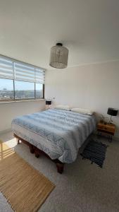 瓦尔帕莱索Vista Valparaíso Barrio Inglés的一间卧室配有一张带蓝色棉被的大床