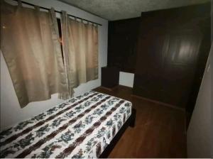 昆卡La Muralla的一间卧室配有床和带窗帘的窗户