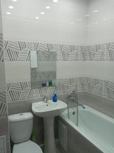 奇姆肯特Квартира的浴室配有盥洗盆、卫生间和浴缸。