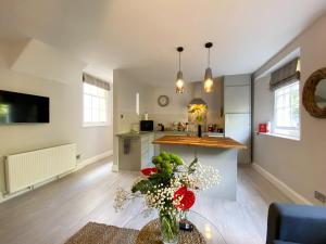 托基Meadfoot Bay Apartment at Hesketh Crescent的客厅设有厨房和带鲜花的桌子