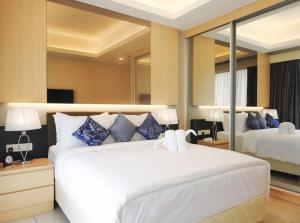 云顶高原至尊玖霄明阁大酒店的卧室配有带蓝色枕头的大型白色床