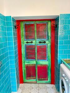 KisapátiMexican style chalett at lake Balaton的蓝色浴室里的一个红色和绿色的门