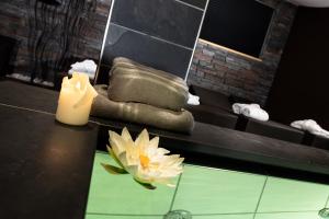 莫埃纳圣维吉利奥运动酒店的浴室设有蜡烛和桌上的花朵