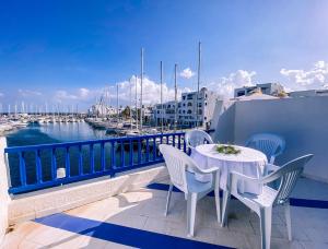 莫纳斯提尔Marina Cap Monastir- Appart'Hôtel的一个带码头的阳台,配有桌椅