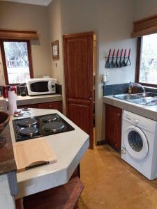 侯斯普瑞特11 Raptors Lodge的厨房配有炉灶和洗衣机。