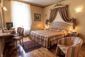 维罗纳克伦巴德欧若酒店的卧室配有一张床和一张桌子及椅子