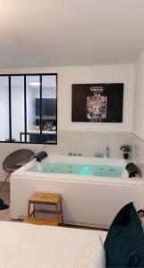 贝桑松L’appart[é] BLACK superbe appartement pop !的带浴缸、桌子和窗户的大浴室