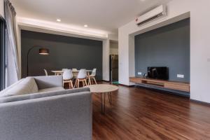 SematanRTS - ROXY Townhouse Sematan - Private - UPPER UNIT的带沙发、桌子和电视的客厅