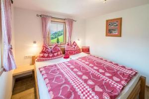 约赫贝格Biohof Vorderreith的一间卧室配有一张带粉色床单的大床和窗户。