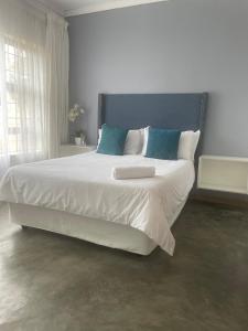波罗瓜尼Maso palace的卧室配有带蓝色枕头的大型白色床