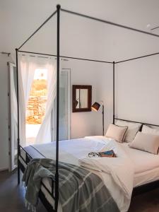 金尼昂Pino di Loto Boutique Bed & Breakfast的一间卧室配有一张天蓬床,上面有一本书