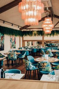 康格尔顿Lion & Swan Hotel的餐厅设有蓝色的桌椅和吊灯。