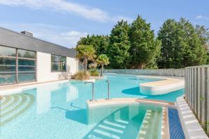 布朗维尔Village Pierre & Vacances Normandy Garden的后院的蓝色海水游泳池